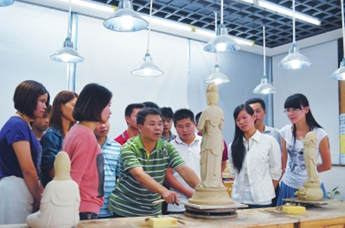 在瓷都德化，省陶瓷艺术大师郑雄文（中）在指导学徒创作。