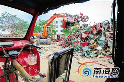 中国侨网工人对风采车进行切割销毁。 本报记者 袁琛 摄