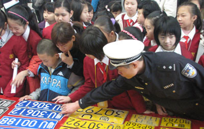 中国侨网民警向学生讲解车号牌真假的辨别方法。