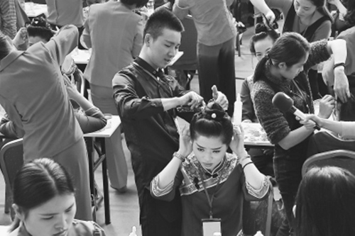 中国侨网图为比赛中,唯一一位男性选手在为女模特梳“妈祖髻”。