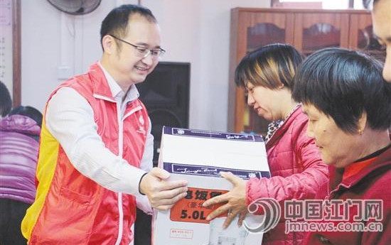 中国侨网江门市福彩中心主任陈威雄为帮扶对象送上“礼物”。