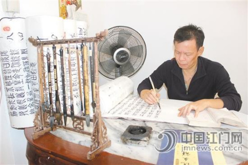 中国侨网马叔正在认真书写《三国演义》。