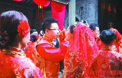 中国侨网昨日(12月18日)，在佛山岭南天地举行的“嫁娶屋”民俗集体婚礼上，新人们在喝交杯酒。 佛山日报记者陈浩森摄 