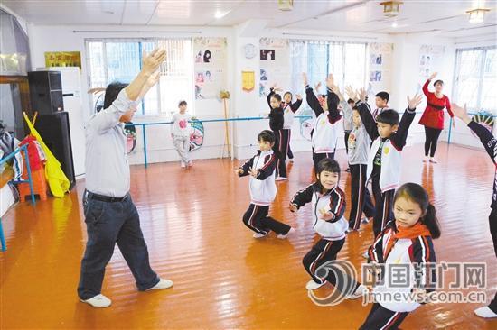 中国侨网伍光明在辅导红豆班学员。