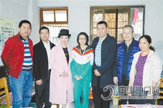 中国侨网会长蒋进（右二），副会长梁耀强（右三）、厉晓晓（左三）及市教育局相关负责人与李妈妈、李艳梅合影。