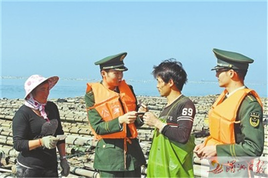 中国侨网图为官兵在渔排上为外来养殖人员送车票。
