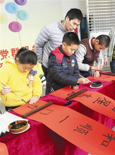 中国侨网孩子们写春联迎新春。