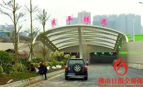 中国侨网隧道入口处，工作人员正在进行绿化整修施工。/佛山日报记者黄才文摄 