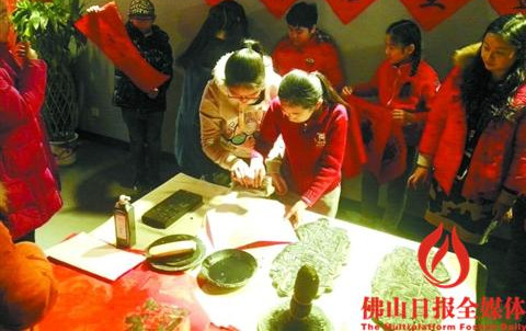 中国侨网北京半步桥小学的学生体验印制木版年画。/通讯员郭文钠供图