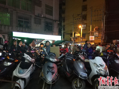 中国侨网 1月11日23时许，与安福电商城一条马路之隔的某地下仓库路口，来此提鞋、送鞋的商家骑着摩托车，路口一时拥堵。中国青年报·中青在线记者 卢义杰/摄