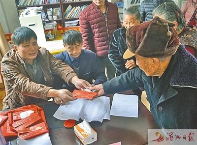 中国侨网老人领取敬老慰问金。