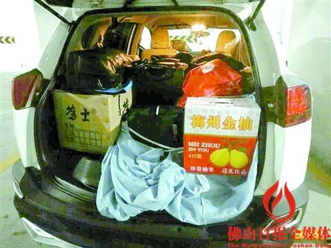 中国侨网客家人小晖的车尾箱装满了沙田柚等家乡特产，还有一整桶鸡鸭鹅。 