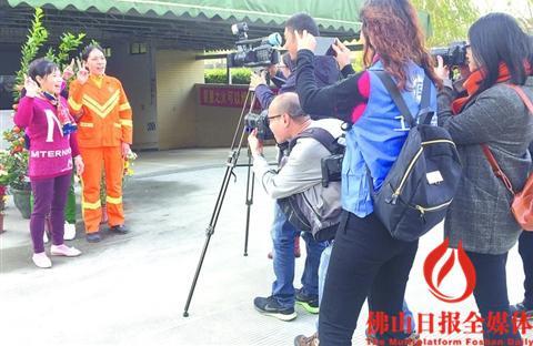 中国侨网2月5日，摄影师们手持长枪短炮为环卫工人拍摄生活照。 　　/佛山日报记者周文琪摄