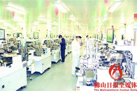 中国侨网国星光电封装车间，工人在操作机器。/企业供图