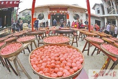 中国侨网泗华村晾晒在大簸箕上的红豆腐丸。
