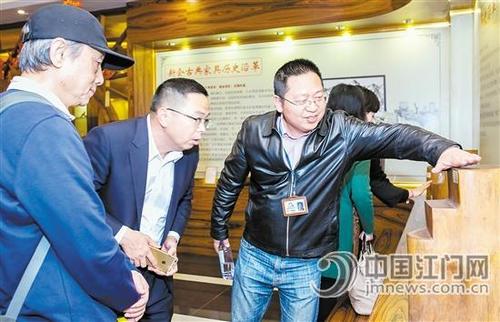 中国侨网新会古典家具城董事长袁秋耘向澳门中华艺术交流促进会一行介绍古典家具。