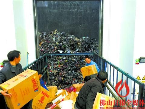 中国侨网工人将非法卷烟投入固体垃圾收集仓,再进行焚烧销毁。 佛山日报记者宋世伟摄