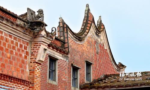 中国侨网林家大院墙头立石狮及墙檐下的精致堆塑。