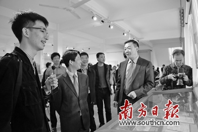 中国侨网广东省岭海档案馆馆长李楷瀚(左一）正在为游客介绍展品背后的故事。