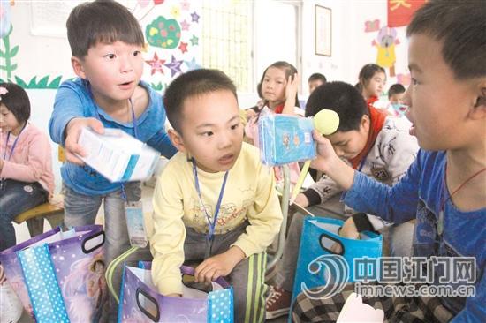 中国侨网留守儿童们收到了礼物显得十分开心。