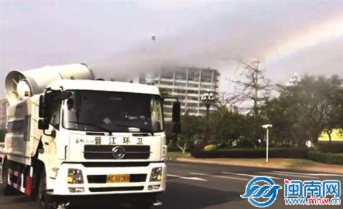 中国侨网抑尘车喷射出的水雾，经阳光折射，形成一道彩虹。