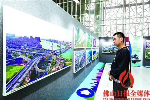 中国侨网一位市民驻足观看航拍照片。/佛山日报记者 王澍摄