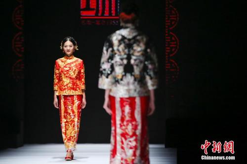 中国侨网2016年11月10日,模特们在T台展示龙凤褂裙。当日,2016中国(潮州)国际婚纱礼服周举行名瑞·婚纱龙凤褂裙发布会,为观众献上一场中西方婚嫁文化盛宴。中新社记者 熊然 摄