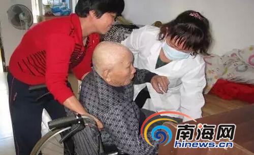 中国侨网图为韩文英(左一)在照顾瘫痪老人。(图片来源:南海网)