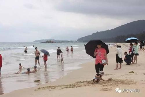 中国侨网游客嬉戏于海边。