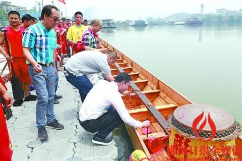 中国侨网大沥中联黄飞鸿龙狮训练基地工作人员正对新龙舟进行“点睛”。/通讯员杨文升供图