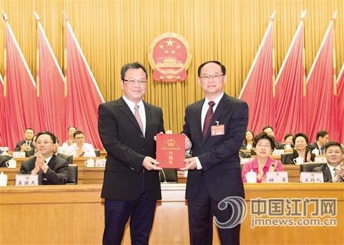 中国侨网市委书记、市人大常委会主任林应武代表大会主席团为新当选的市长刘毅颁发当选证。江门日报记者 周华东 摄