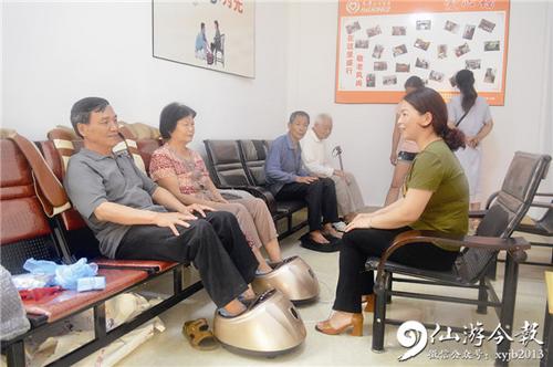 中国侨网老人在养老护理员的帮助下进行足底按摩。
