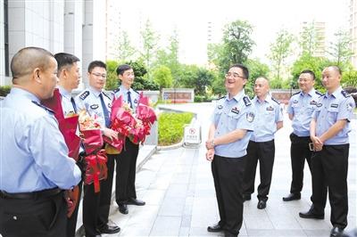 中国侨网受市委常委、公安局长罗杰委托,市公安局政治部主任黄伟军迎接获奖英模并送上鲜花。 图片由市公安局提供