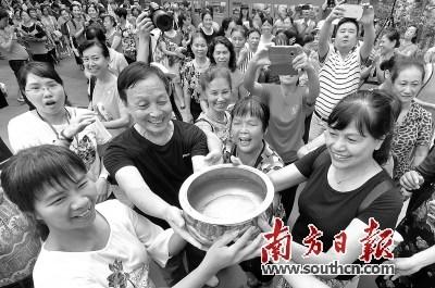 中国侨网装有塔坡水的铜磬，通过善心人士组成的队伍接力运送到拜祭舞台。 戴嘉信 摄