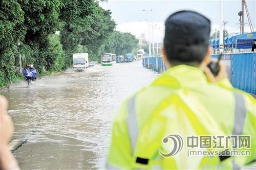 中国侨网7月4日早上，新会陈皮村至大洞桥路段积水严重，交警到场实施交通管制。 张奕维摄
