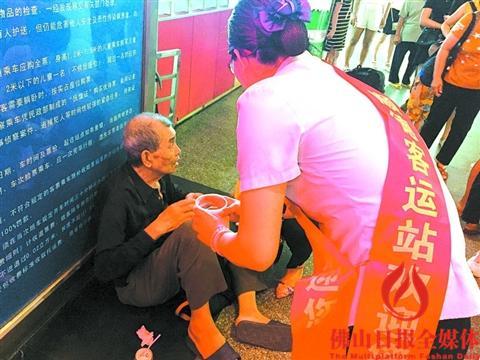 中国侨网工作人员在旁边照料老人。(区嘉燕 摄)