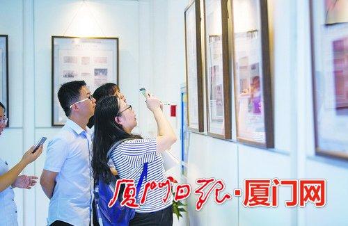 中国侨网本报记者在拍摄关于鼓浪屿音乐厅的剪报。