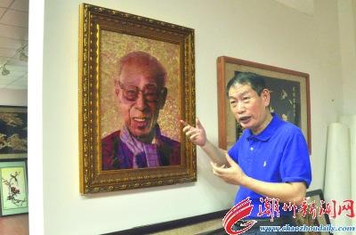 中国侨网方志伟向记者介绍麦秆画《汉学家饶宗颐》的创作过程。