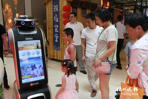 中国侨网市民被机器人吸引，纷纷驻足围观。