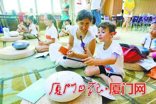 中国侨网亲子互动,学习弹奏色空。(本报记者 王协云 摄)