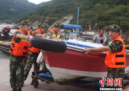 中国侨网图为边防官兵帮民众转移船只。王华　摄