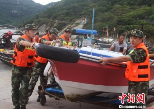 中国侨网图为边防官兵帮民众转移船只。王华 摄
