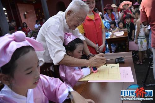 中国侨网图为亲子游家庭在孔庙观摩开笔仪式。