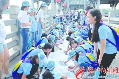 中国侨网22日下午，参加福彩夏令营的小朋友们在广济桥上以“六城同创”“治六乱”为主题绘制长卷。 本报记者 陈翊 摄