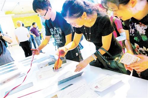 中国侨网观众在首都博物馆华侨护照展现场体验展览互动活动。