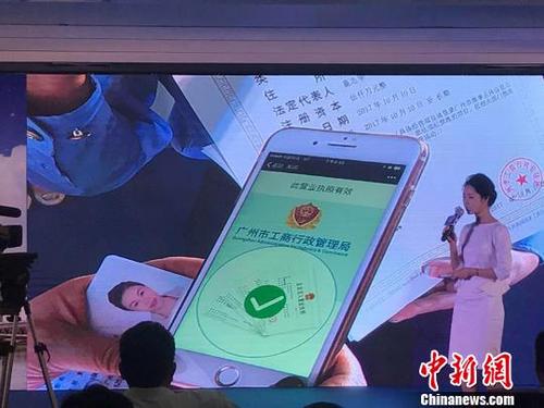 中国侨网10日,广州市工商局举行“人工智能+机器人”(AIR)全程电子化商事登记系统启动仪式。图为在启动仪式现场,一商事主体负责人现场成功办理商事登记。 许青青 摄