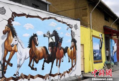 中国侨网开源村中，一幅幅惟妙惟肖、栩栩如生的3D墙画将村落里的民居装扮一新。　张斌　摄