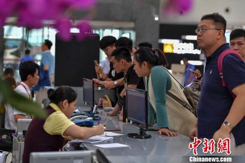 中国侨网 图为海口美兰国际机场航站楼内服务台聚集了前来改签问询的旅客。　骆云飞　摄