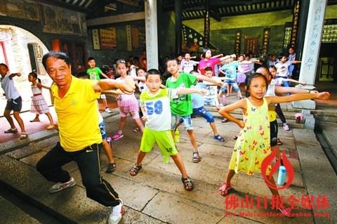 中国侨网参加塔坡社区爱心课堂的小朋友在鸿胜纪念馆教练指导下学习蔡李佛拳。/佛山日报记者张弘弢摄(资料图片)