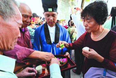 中国侨网“乞龟”活动中,民众吃重阳糕,饮菊花酒。 本组图片由本报记者 游庆辉 摄